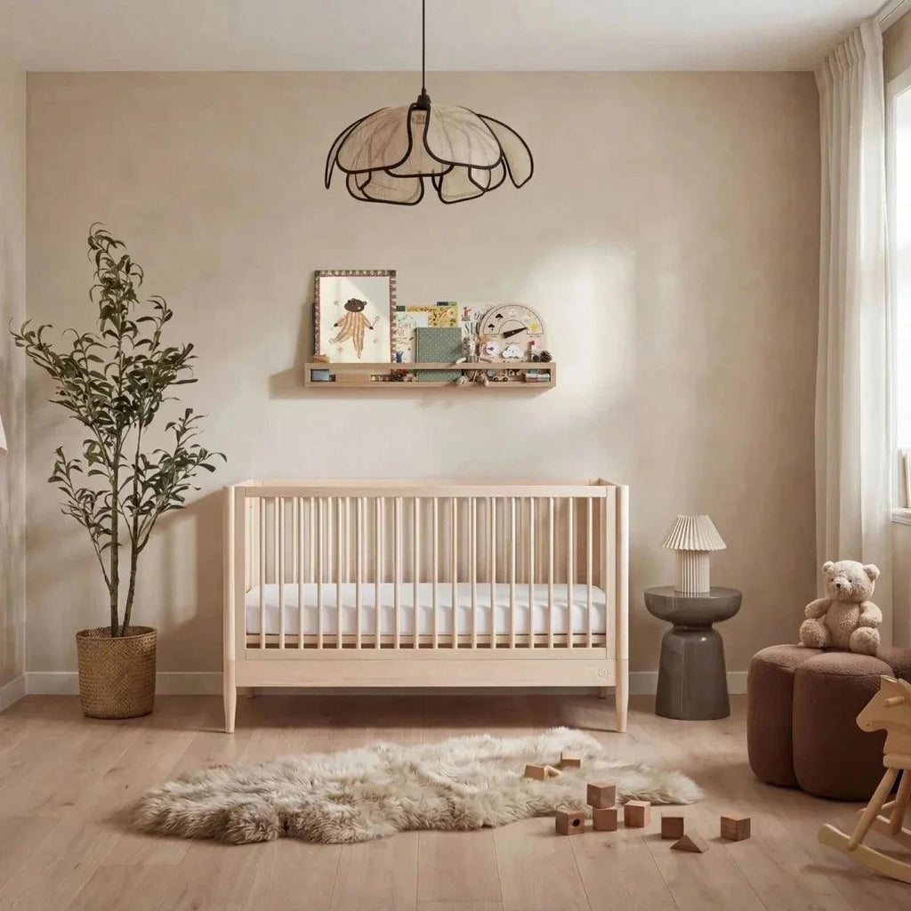 Natural ash baby cot bed with vertical slat sides and low guard rails