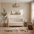 Natural ash baby cot bed with vertical slat sides and low guard rails