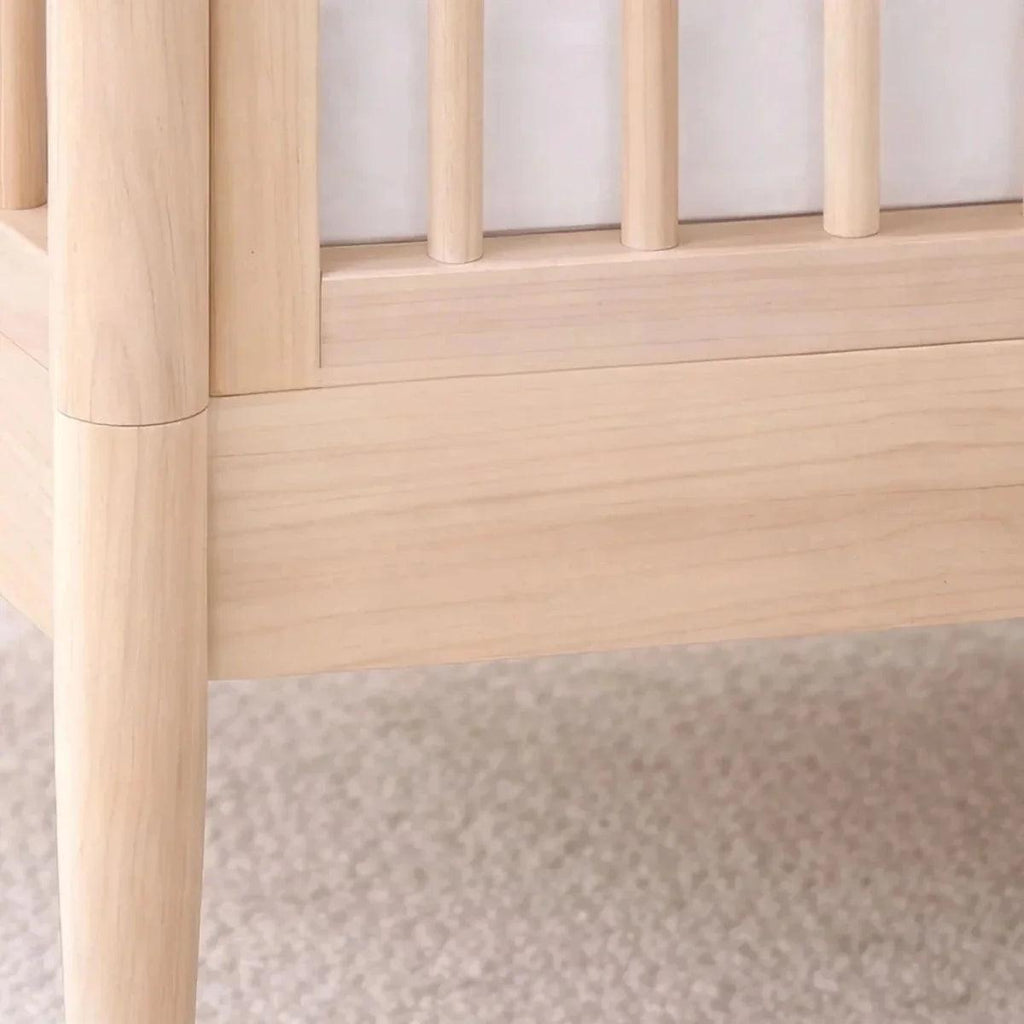 Natural ash cot bed side rail detail with smooth light wood finish