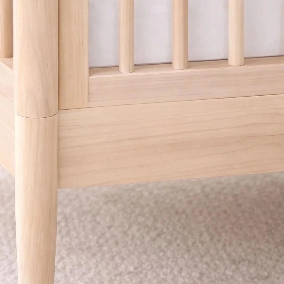Natural ash cot bed side rail detail with smooth light wood finish