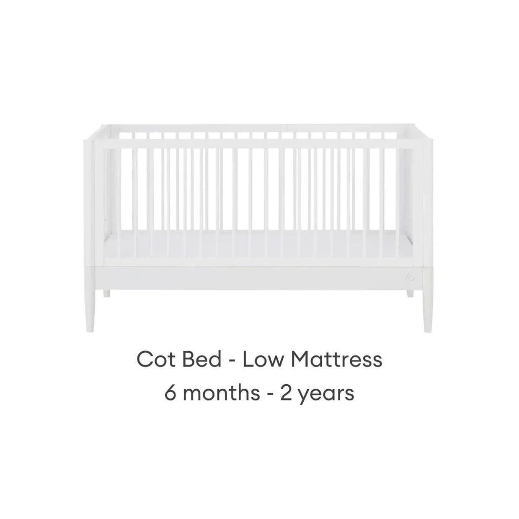 White cot bed with low mattress position and vertical slat guard rails