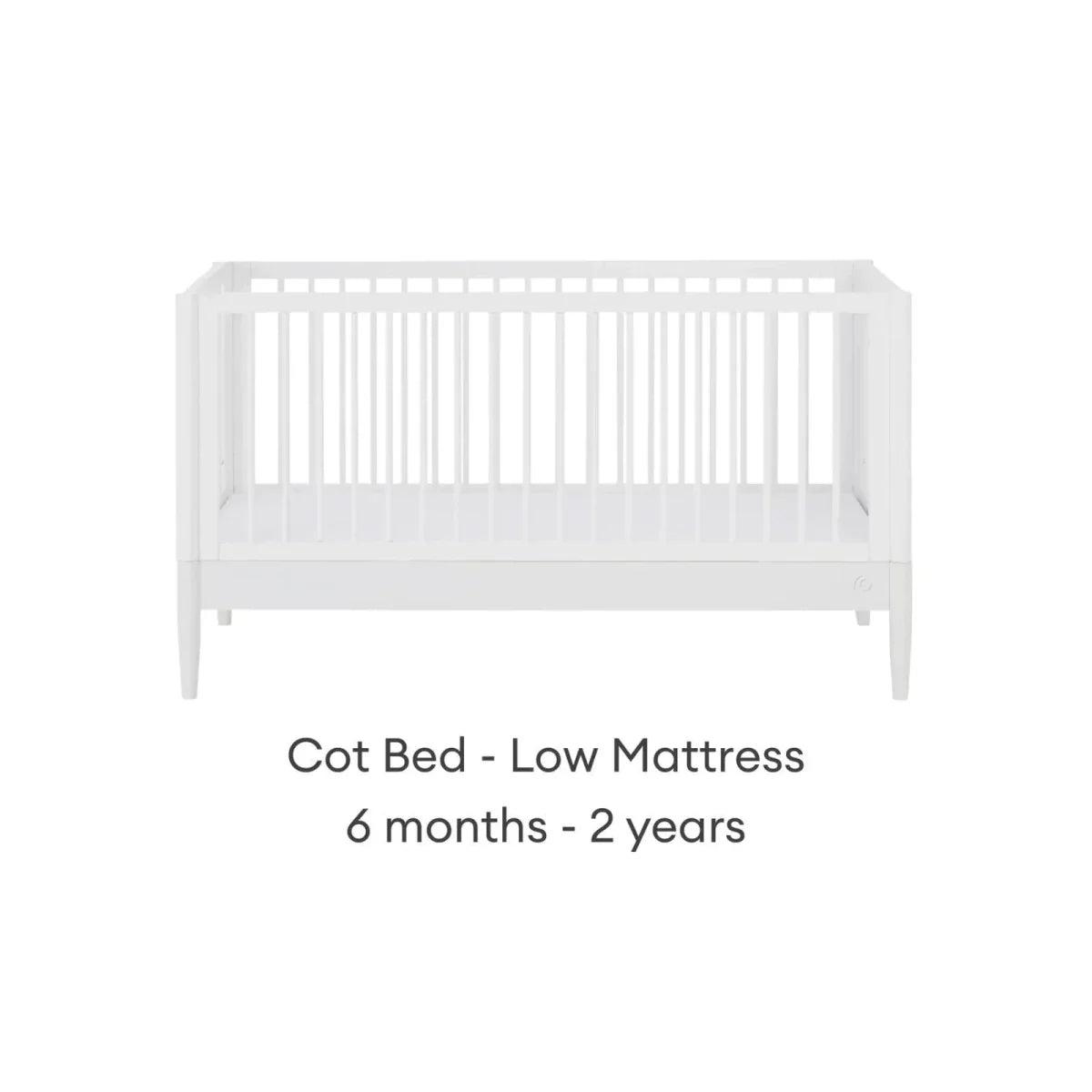 White cot bed with low mattress position and vertical slat guard rails