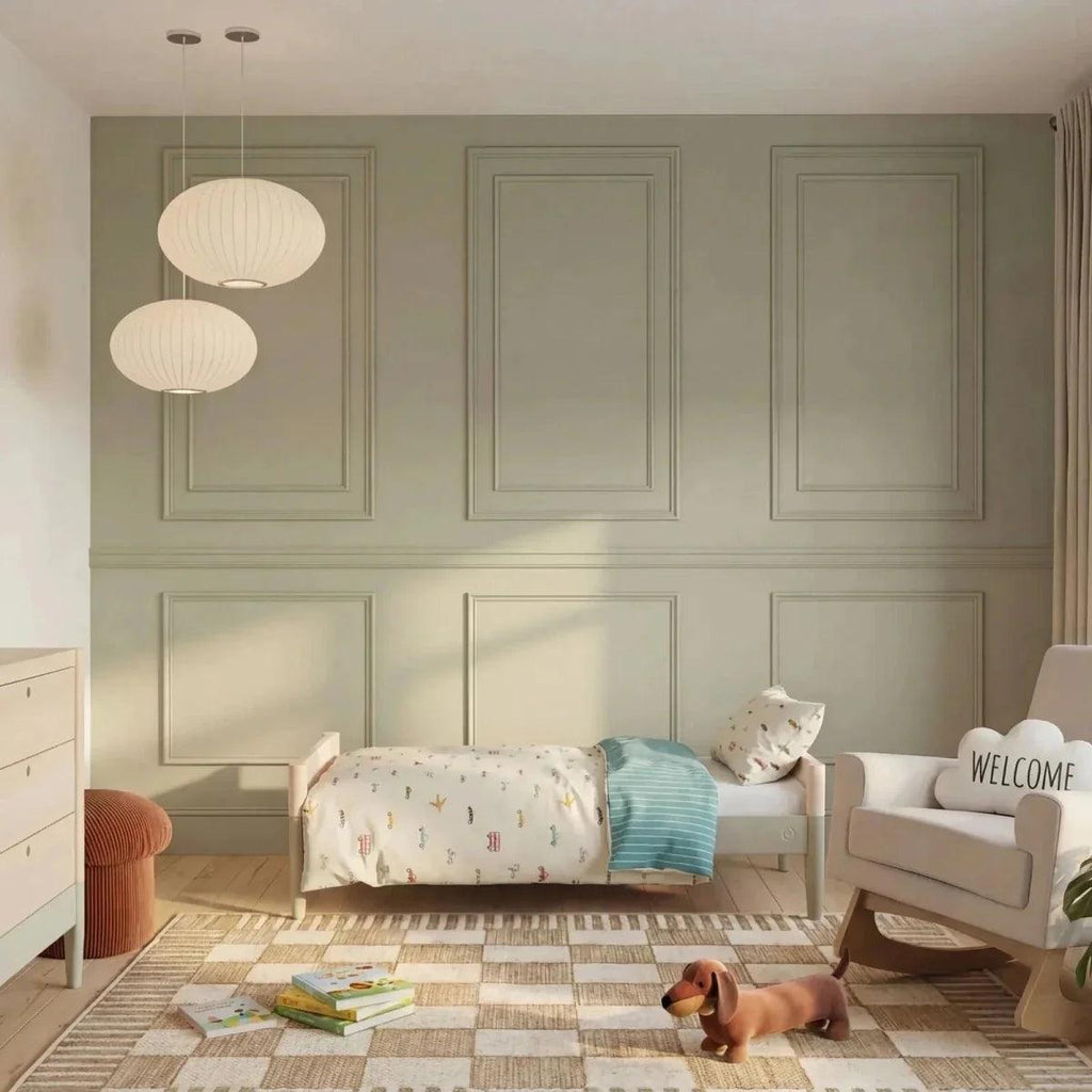 Baby cot bed with vertical slats and natural wood sides, desert sage trim in nursery