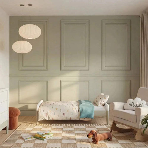 White baby cot bed with open slatted sides and light wood legs in a nursery setting