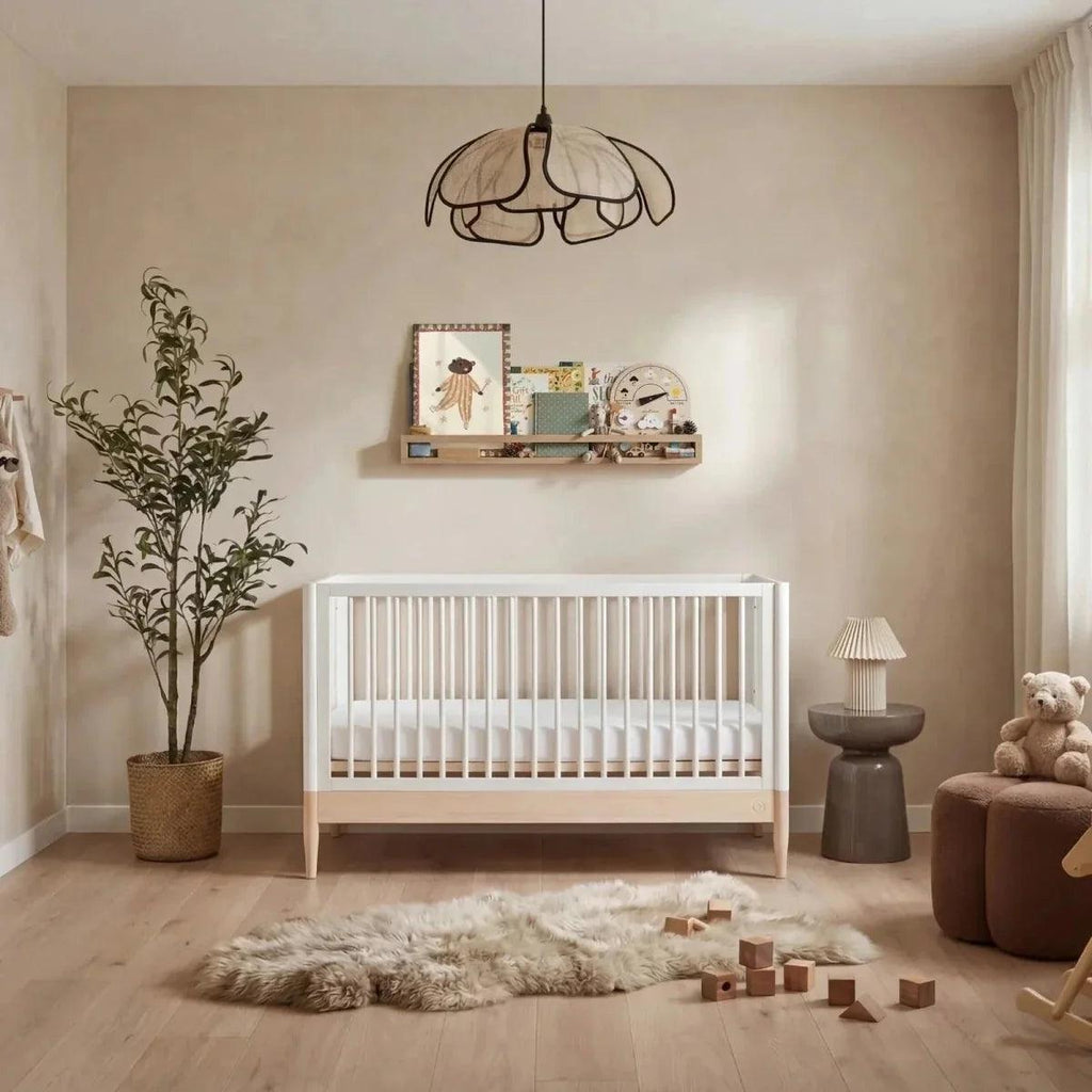 Natural ash and white baby cot bed with vertical slat rails and sturdy legs.