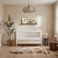 Natural ash and white baby cot bed with vertical slat rails and sturdy legs.