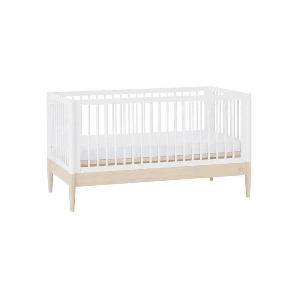 White cot bed with slatted sides and natural wood lower trim in a front view.