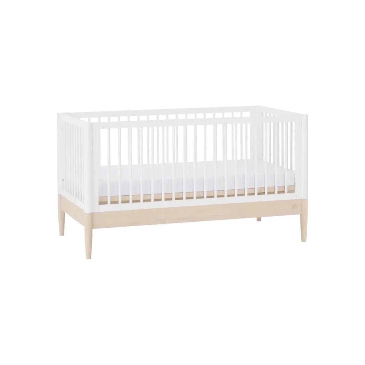 White cot bed with slatted sides and natural wood lower trim in a front view.