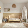 Two-tone primrose yellow and natural ash cot bed with vertical slats and open sides