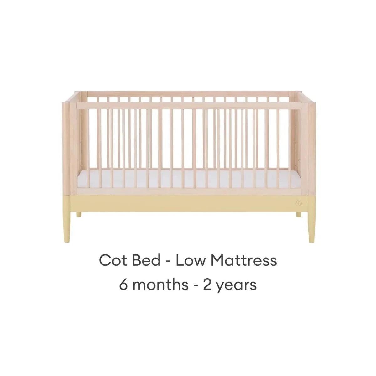Cot bed frame in natural wood with primrose yellow panel and low mattress position