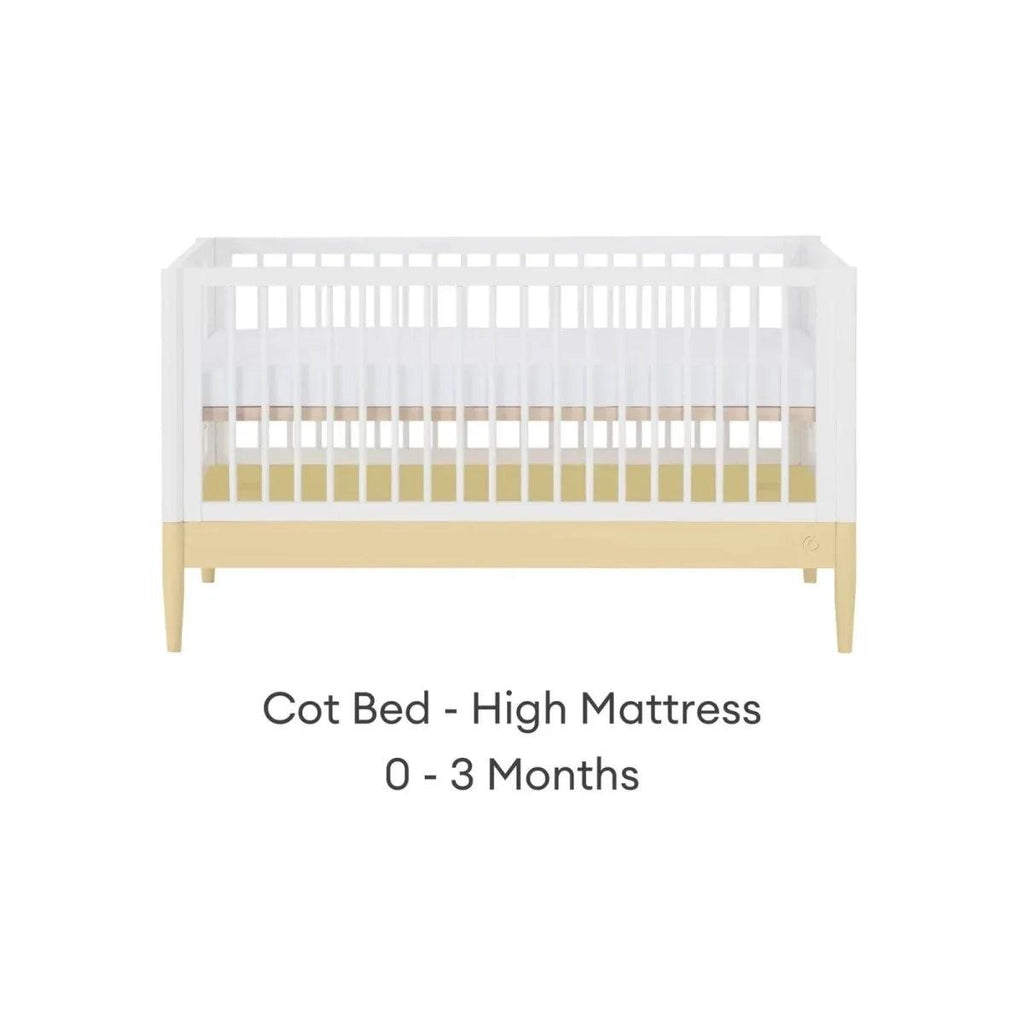Cot bed with white slatted sides, primrose yellow rail, and light wood legs