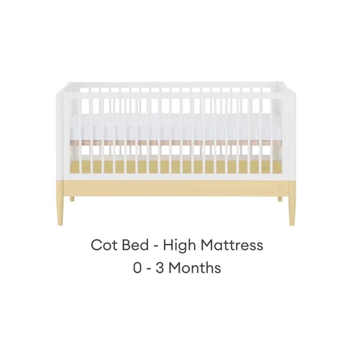 Cot bed with white slatted sides, primrose yellow rail, and light wood legs