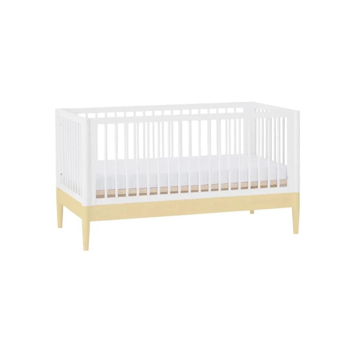 Convertible nursery cot bed with white slatted sides, primrose yellow rail, and legs