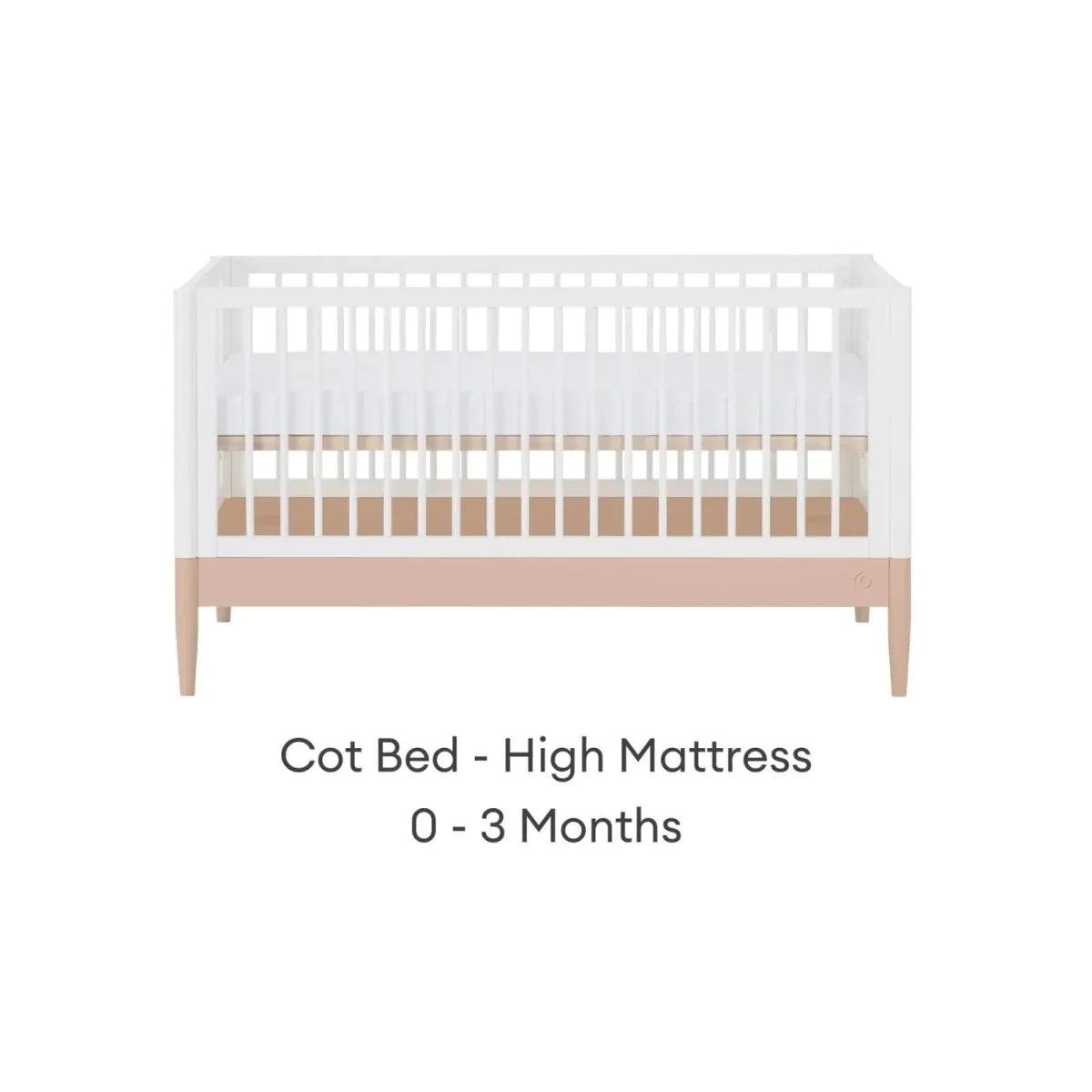 White cot bed with powder blush rail and vertical slats, high mattress position