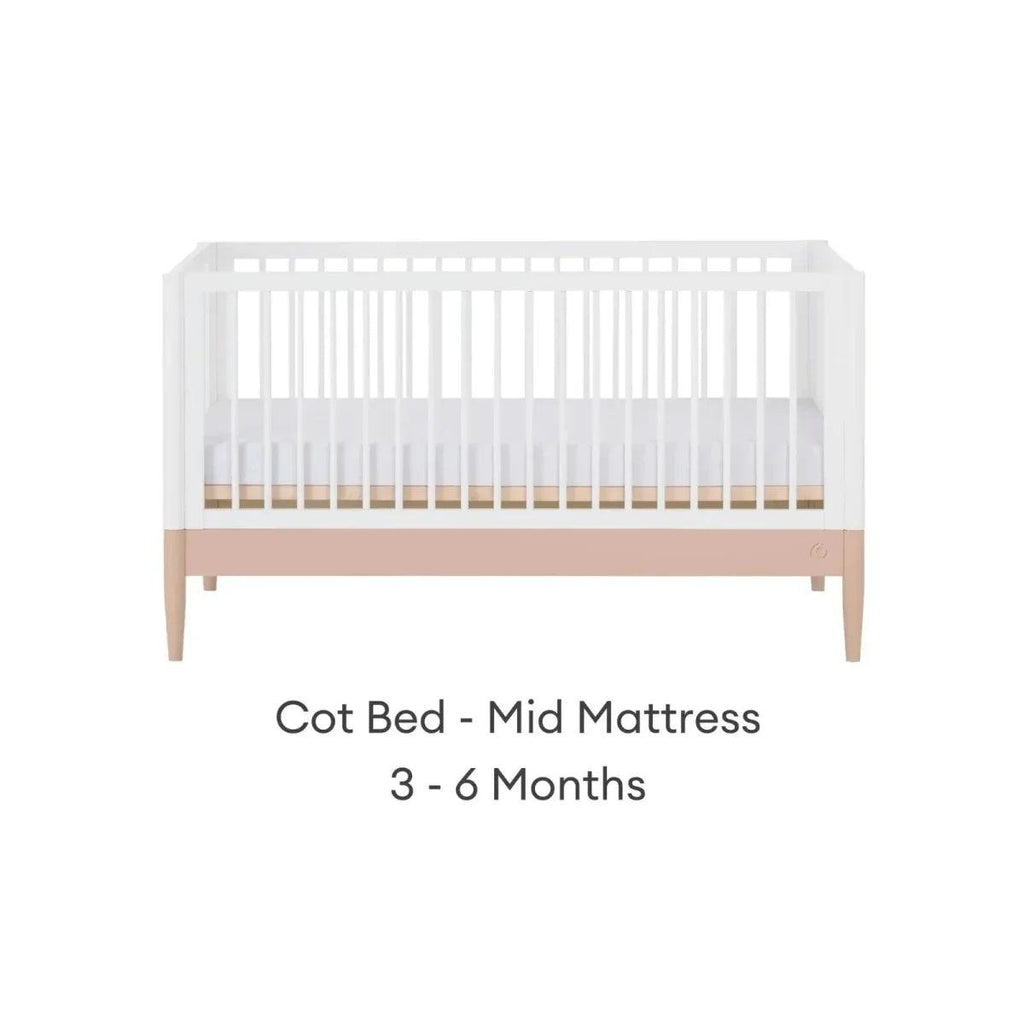White cot bed with powder blush rail and vertical slats, mid mattress position