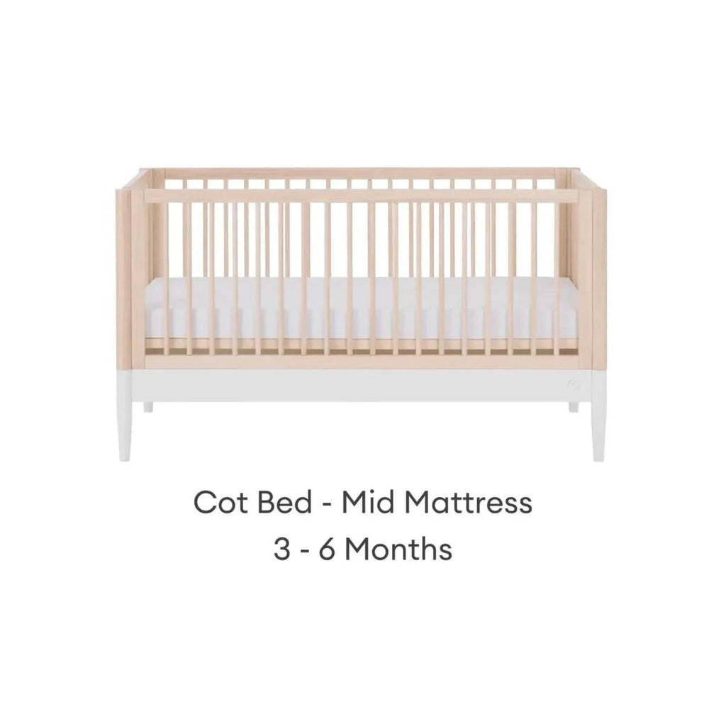 White and natural ash cot bed with mid mattress position and vertical slat guardrails