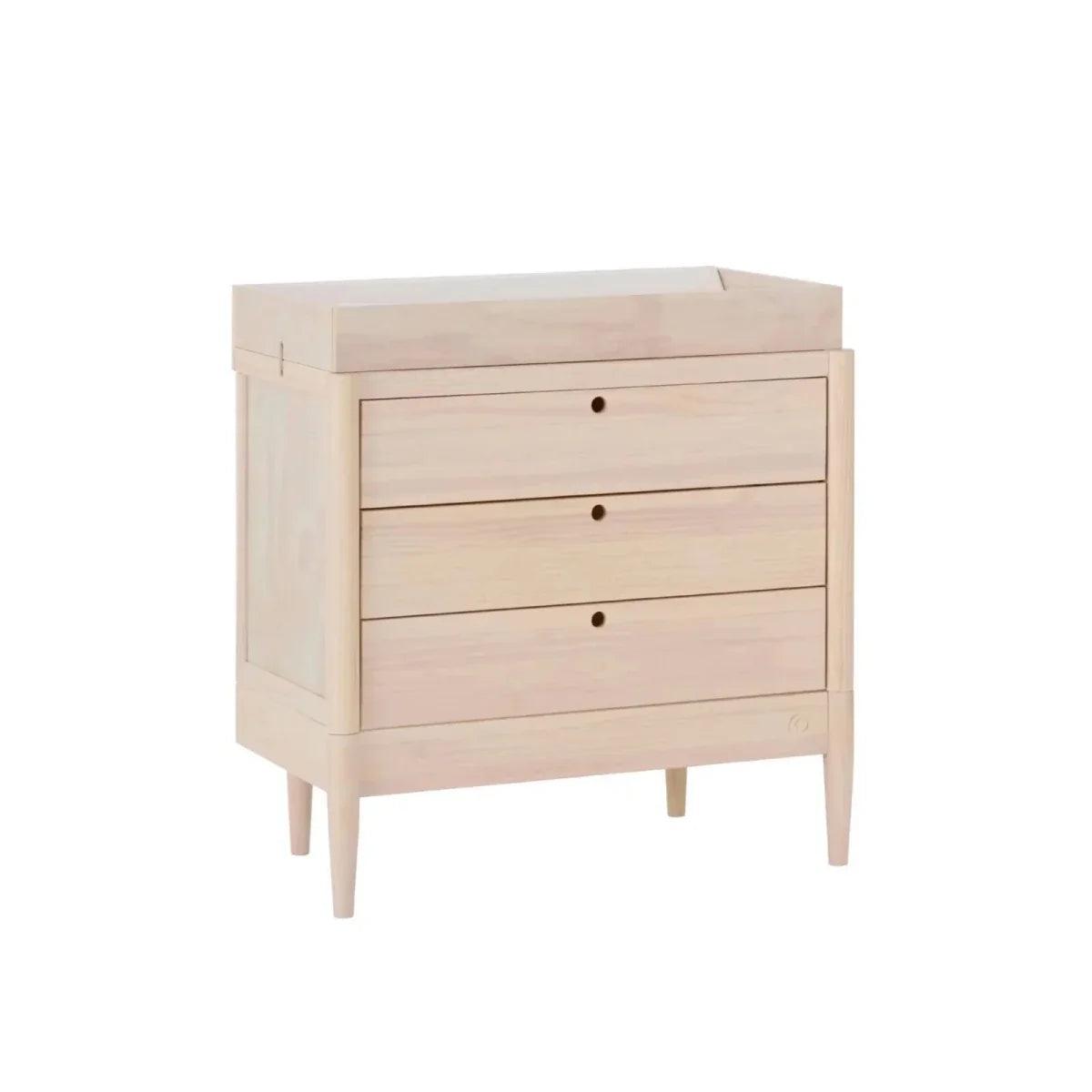 Light ash wood baby dresser with three drawers, slim legs, and round knobs