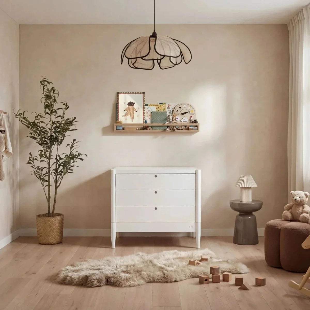 White baby dresser with three drawers and round gold knobs on short legs