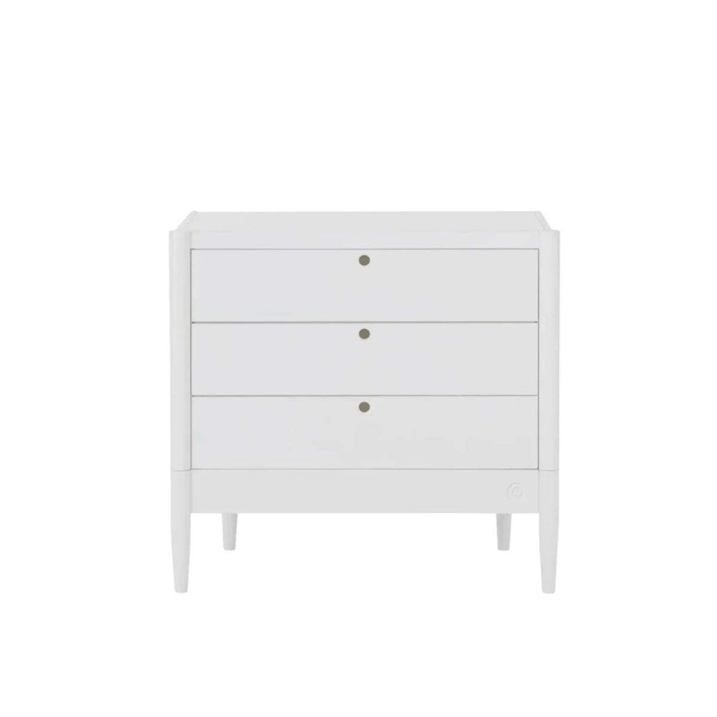 White baby dresser with three drawer fronts and gold knobs, raised on legs
