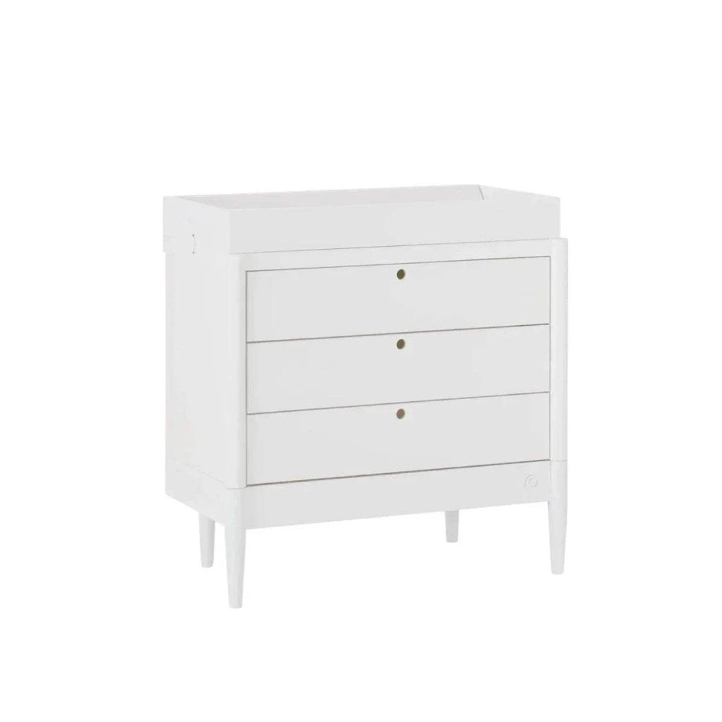 White baby dresser side view, three drawers with gold knobs and turned feet