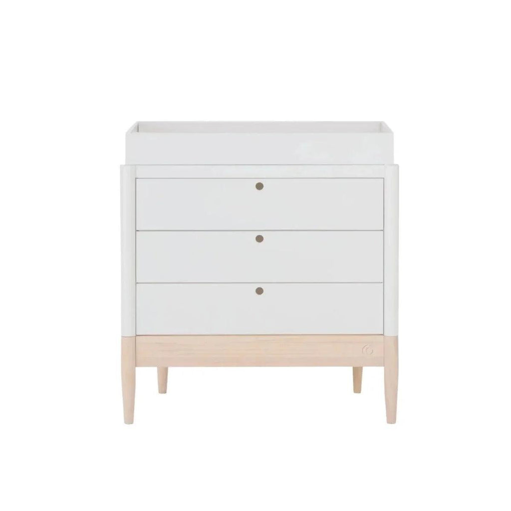 Front view of white baby dresser with three drawers and round brass-tone pulls
