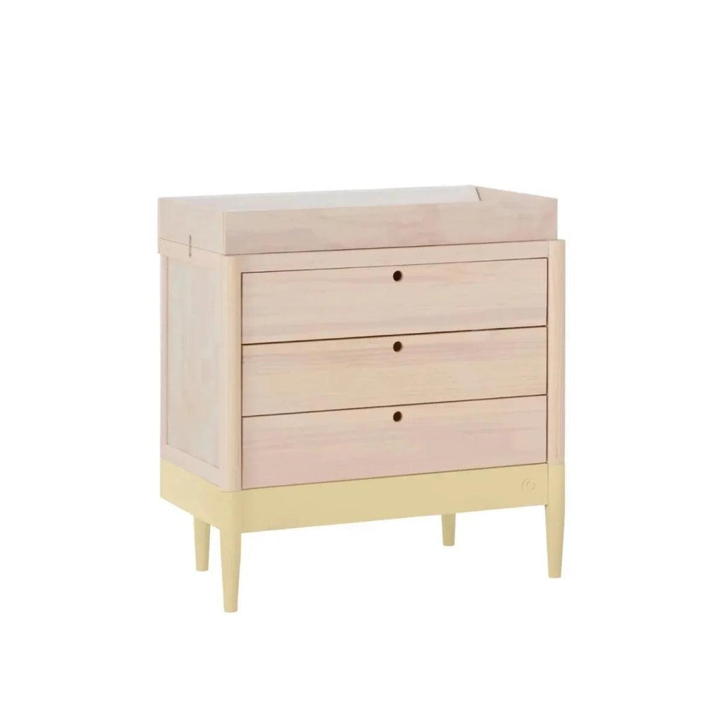 Baby dresser angled view with three drawers, pale wood case and primrose yellow feet.
