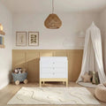 Two-tone baby dresser with three drawers, white top and primrose yellow base, tapered legs