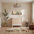 White and natural baby dresser with three drawers and dark round knobs