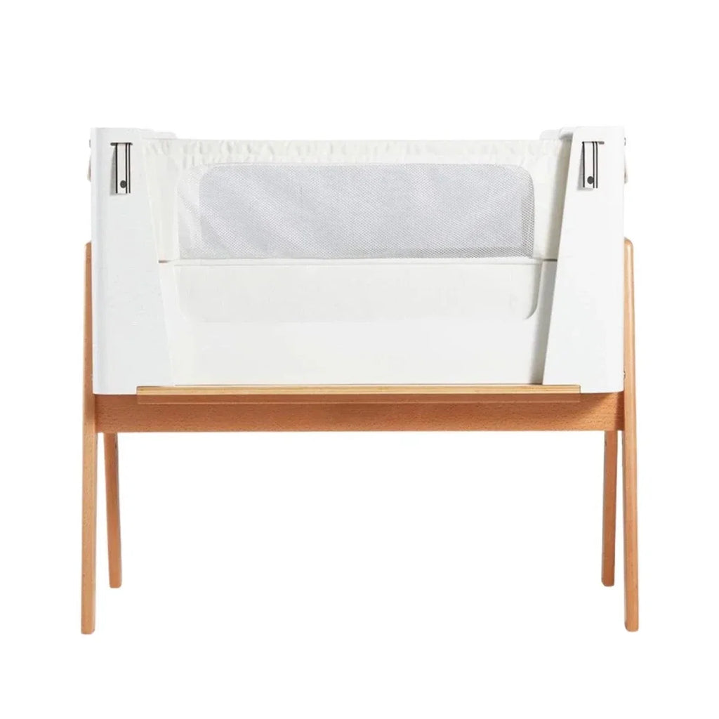 White and natural bedside crib with open side panels and mesh window