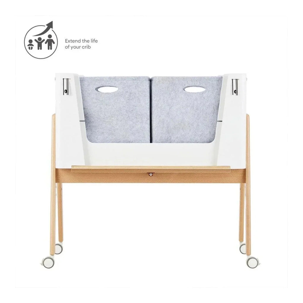 White and natural baby bedside crib with gray padded liner sections