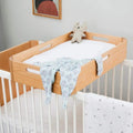 Natural wood changing station top with light fabric insert and side rails