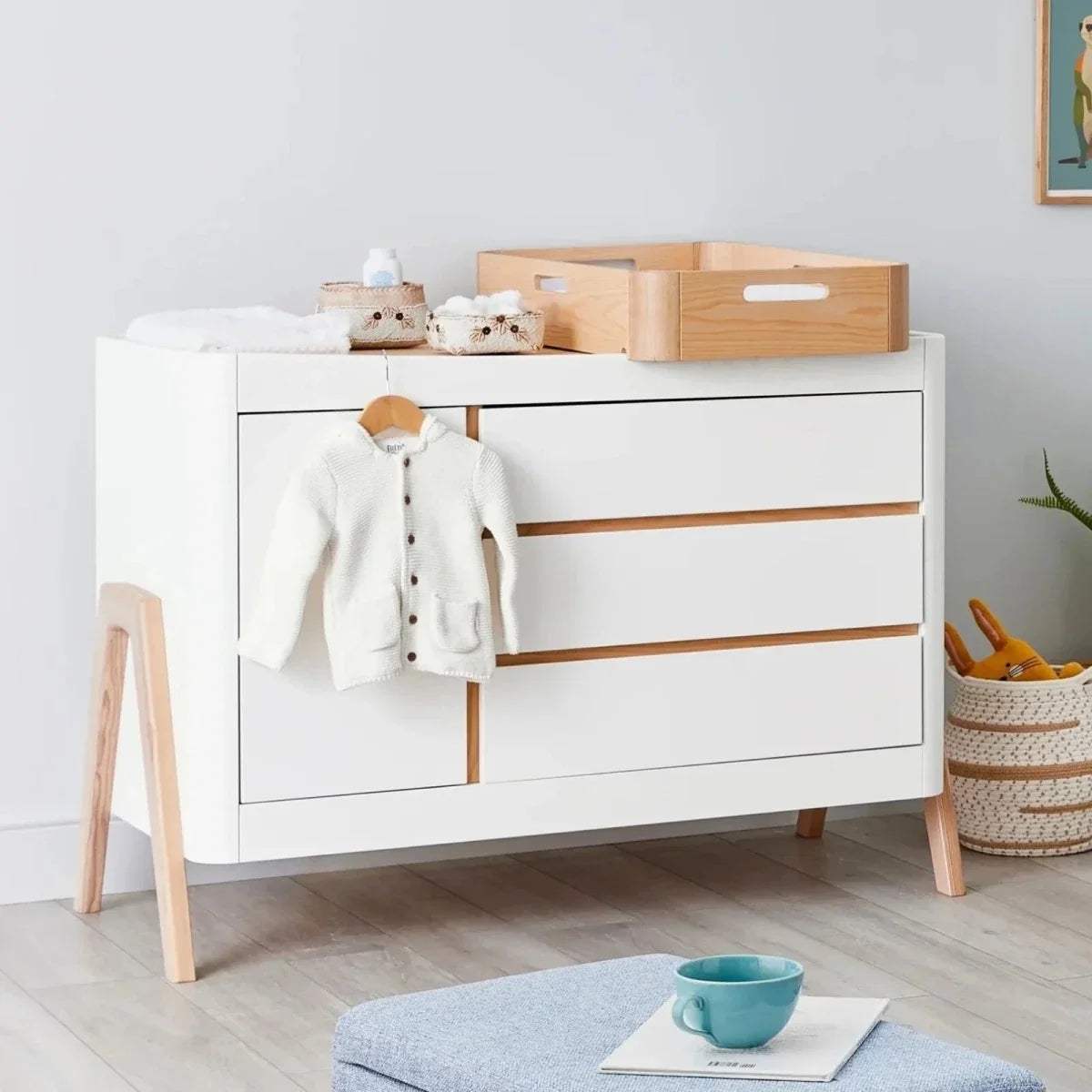 White-and-natural wood changing station cabinet with drawers and changing top