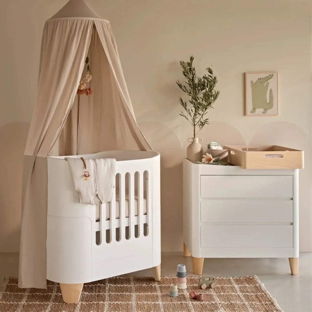 Natural wood baby changing station with white storage cabinet and top ledge