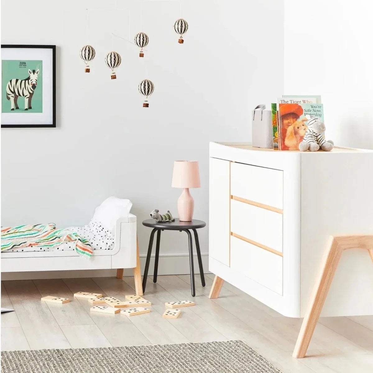 White baby dresser featuring natural wood trim and two front drawers on light legs.