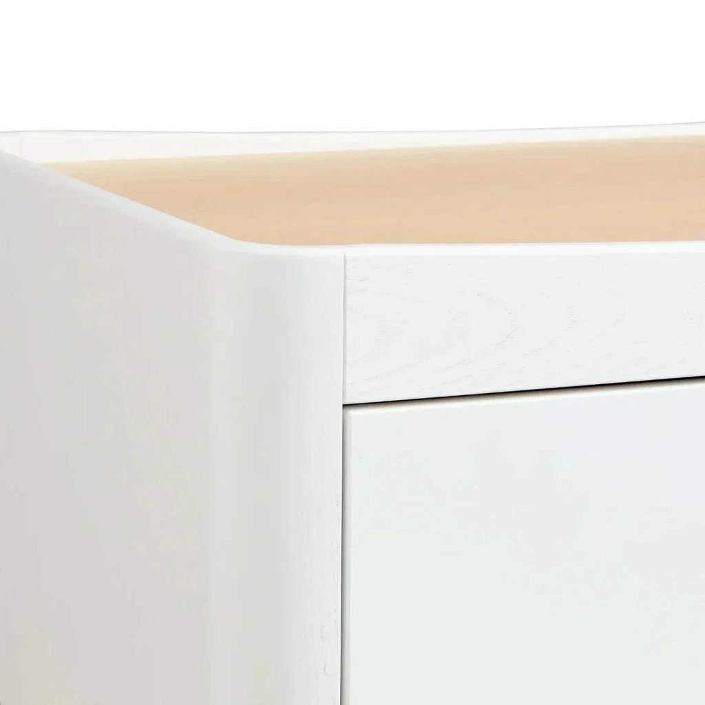 Close-up of white dresser side panel and top edge with smooth, seamless finish.
