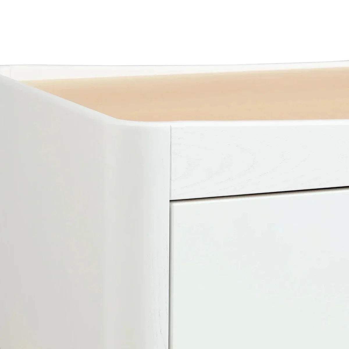 Close-up of white dresser side panel and top edge with smooth, seamless finish.