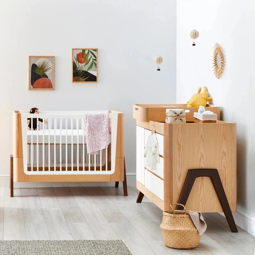 Light wood baby dresser with white drawer fronts and open top cubby