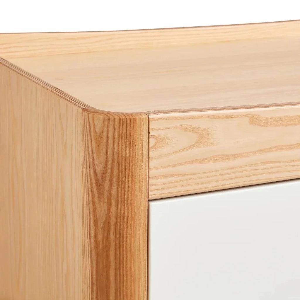 Close-up of natural wood dresser corner with smooth edge and drawer face