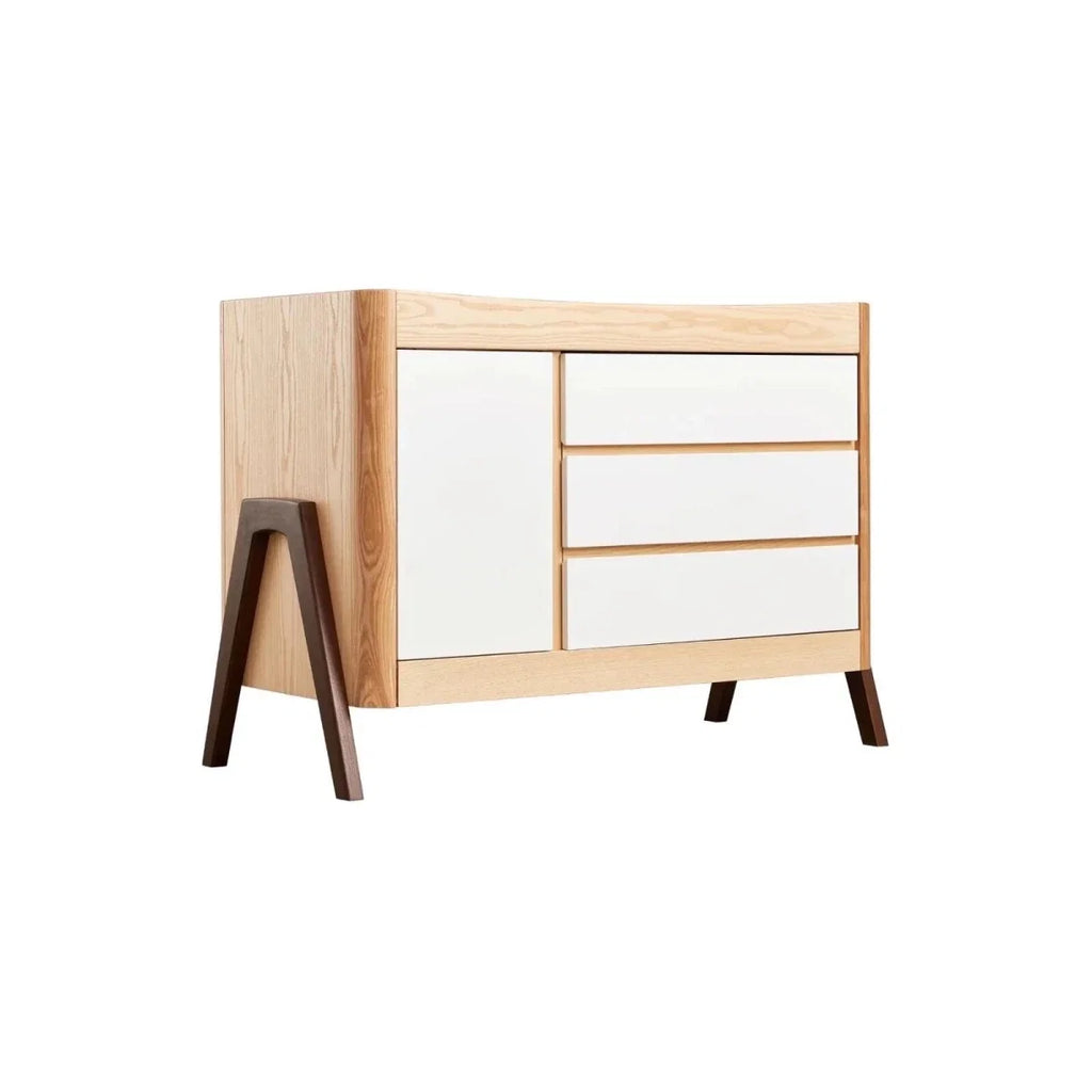 Front view of natural wood baby dresser with white drawers and dark legs
