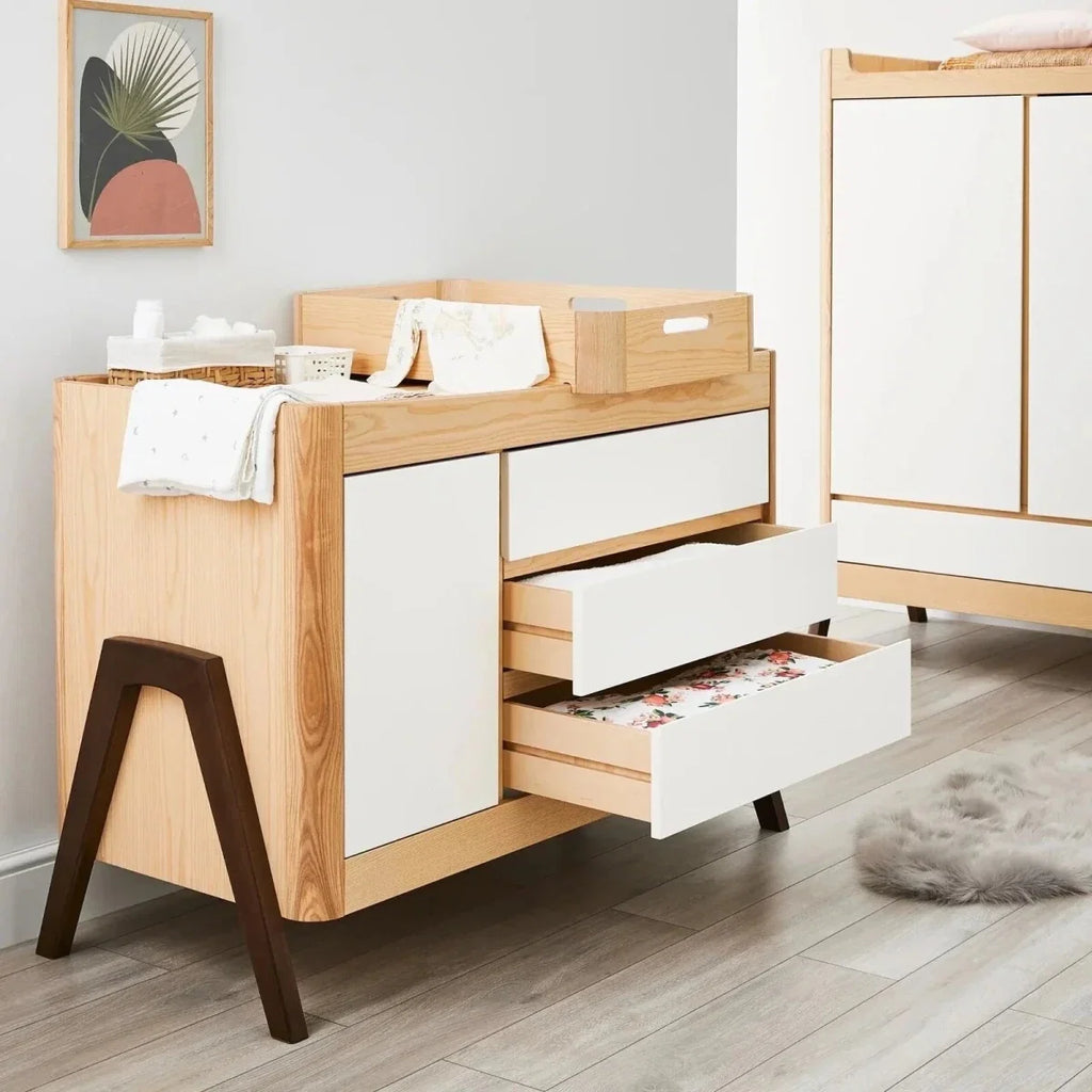 Baby dresser in natural wood with white drawers and open cabinet door