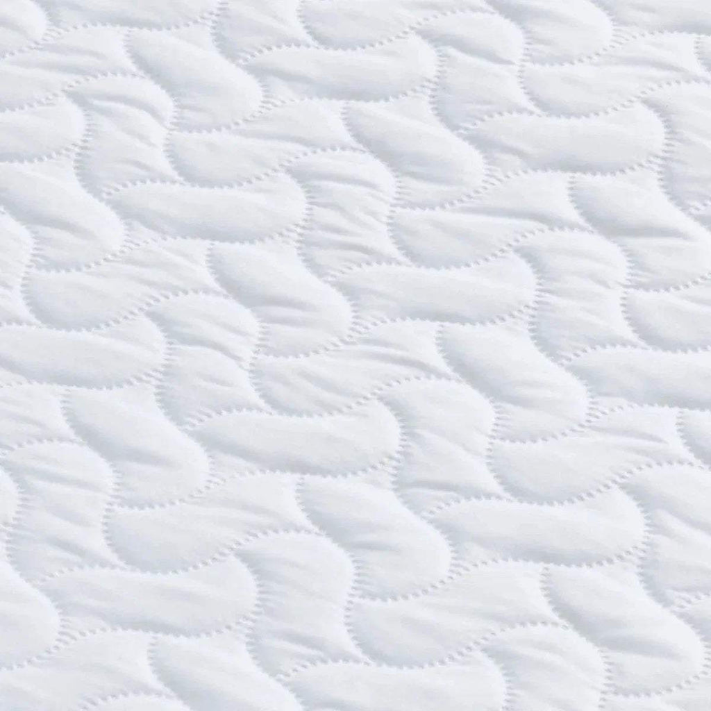 White quilted mattress surface with repeating wave and loop stitch pattern.