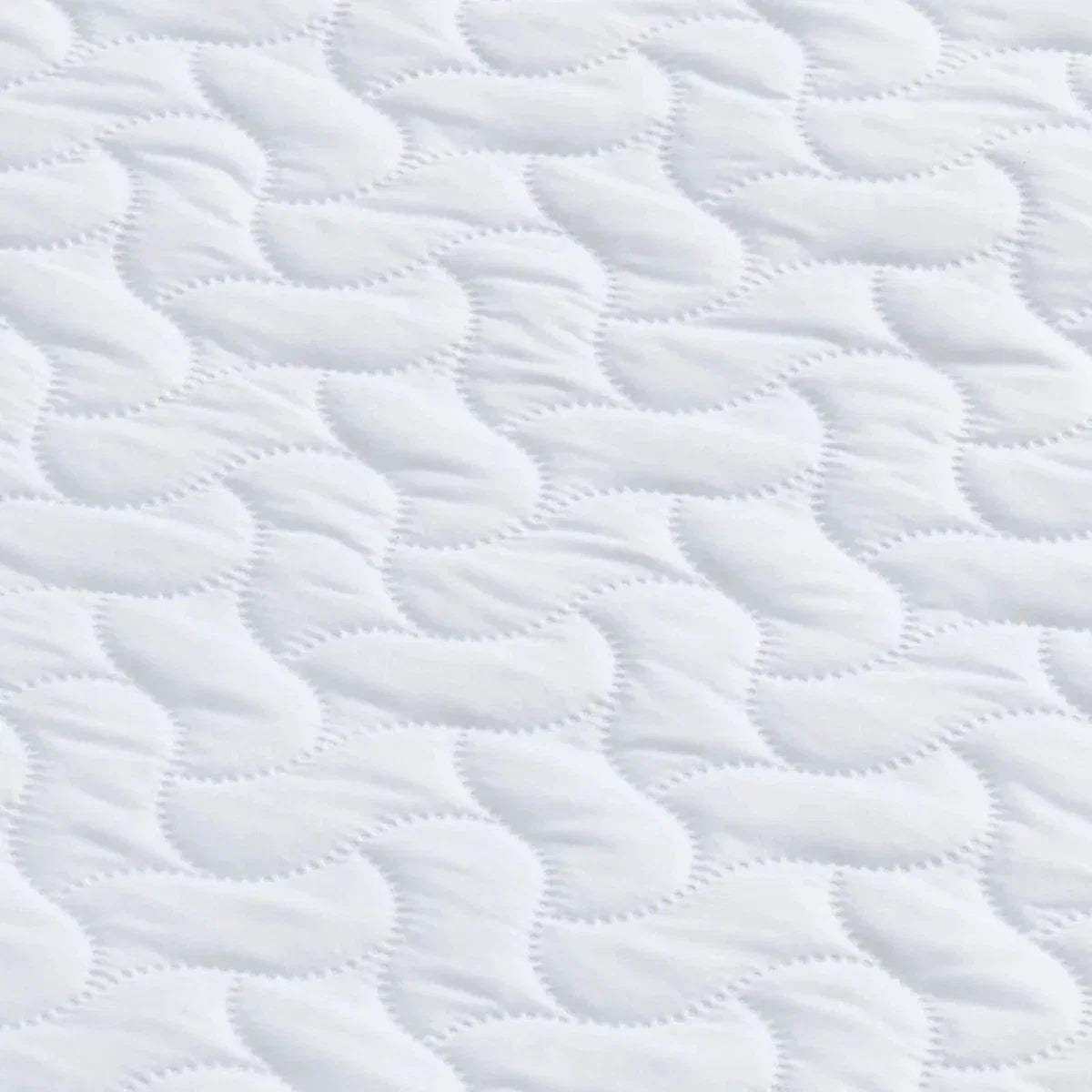 White quilted mattress surface with repeating wave and loop stitch pattern.
