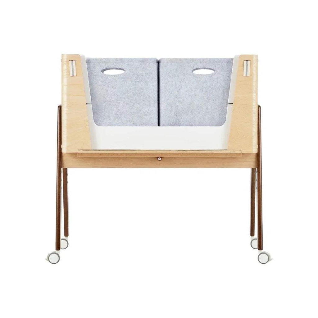 Set of two light gray felt storage boxes on wooden bedside crib frame with oval cutouts