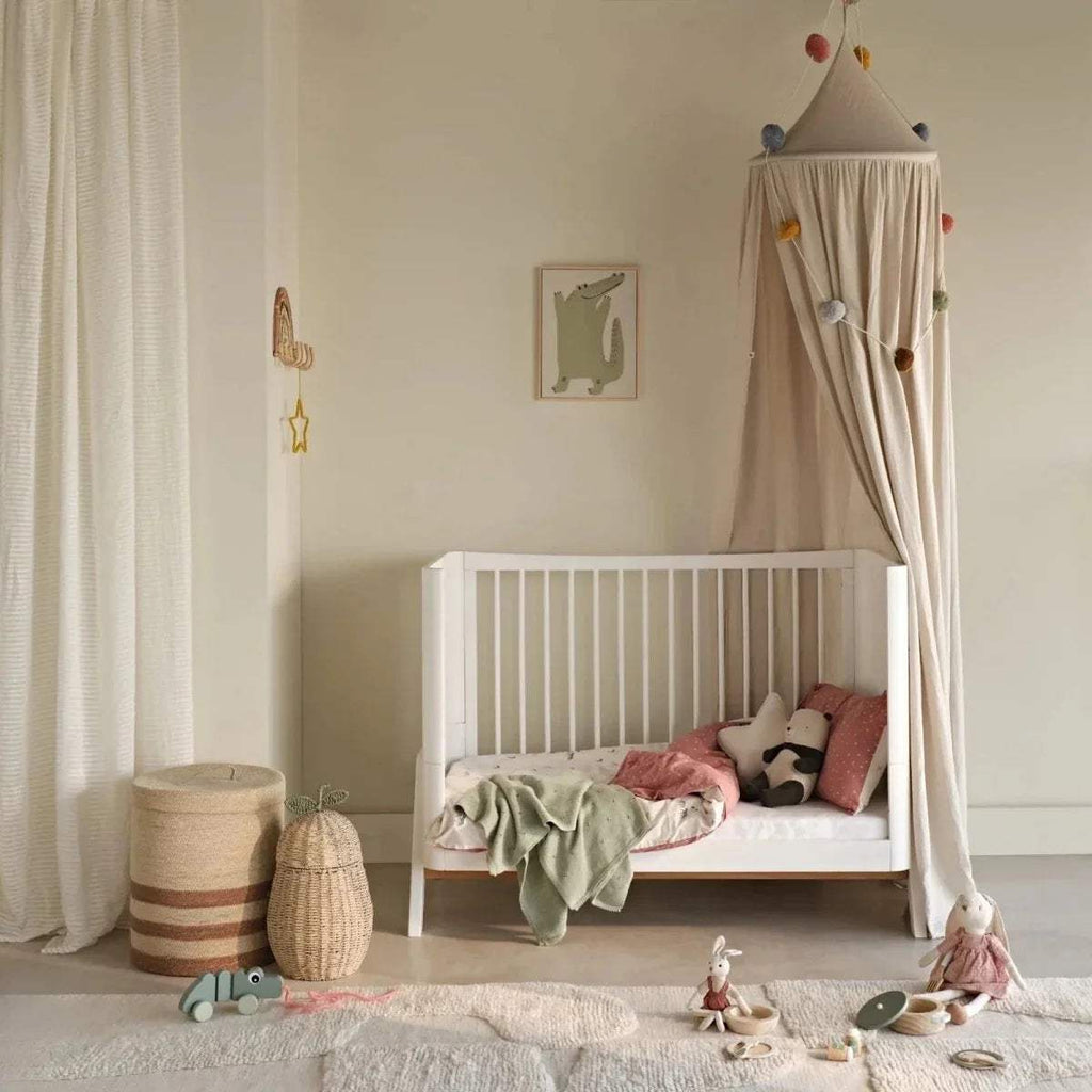 Baby cot bed fitted sheet, white, on mattress in nursery setup