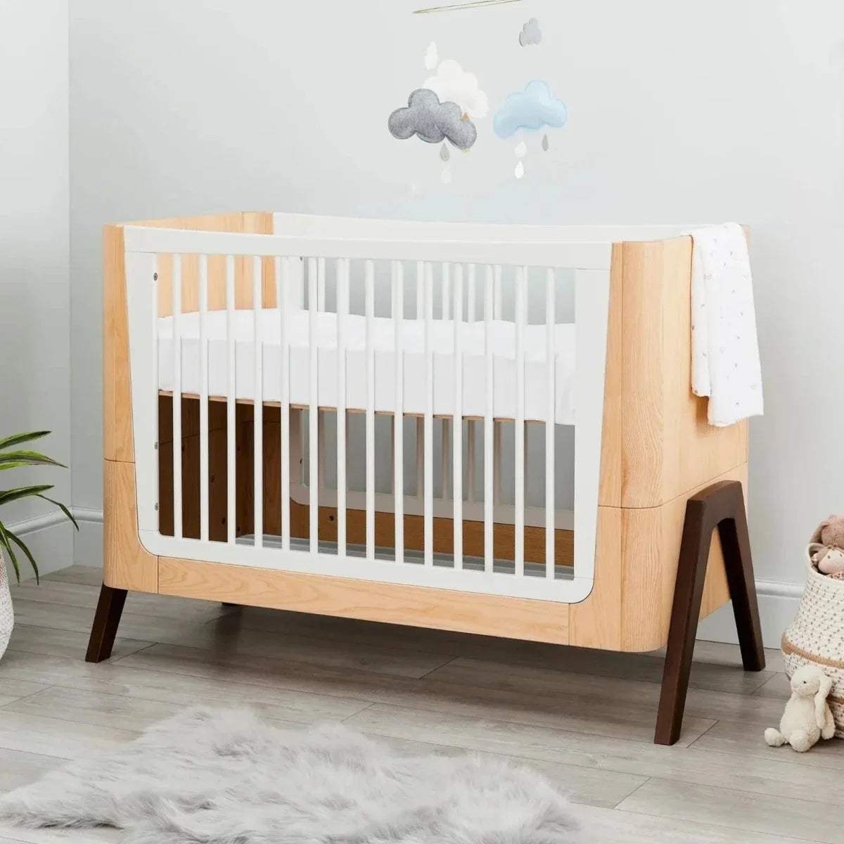 Baby cot bed fitted sheet, white on mattress, cot side view