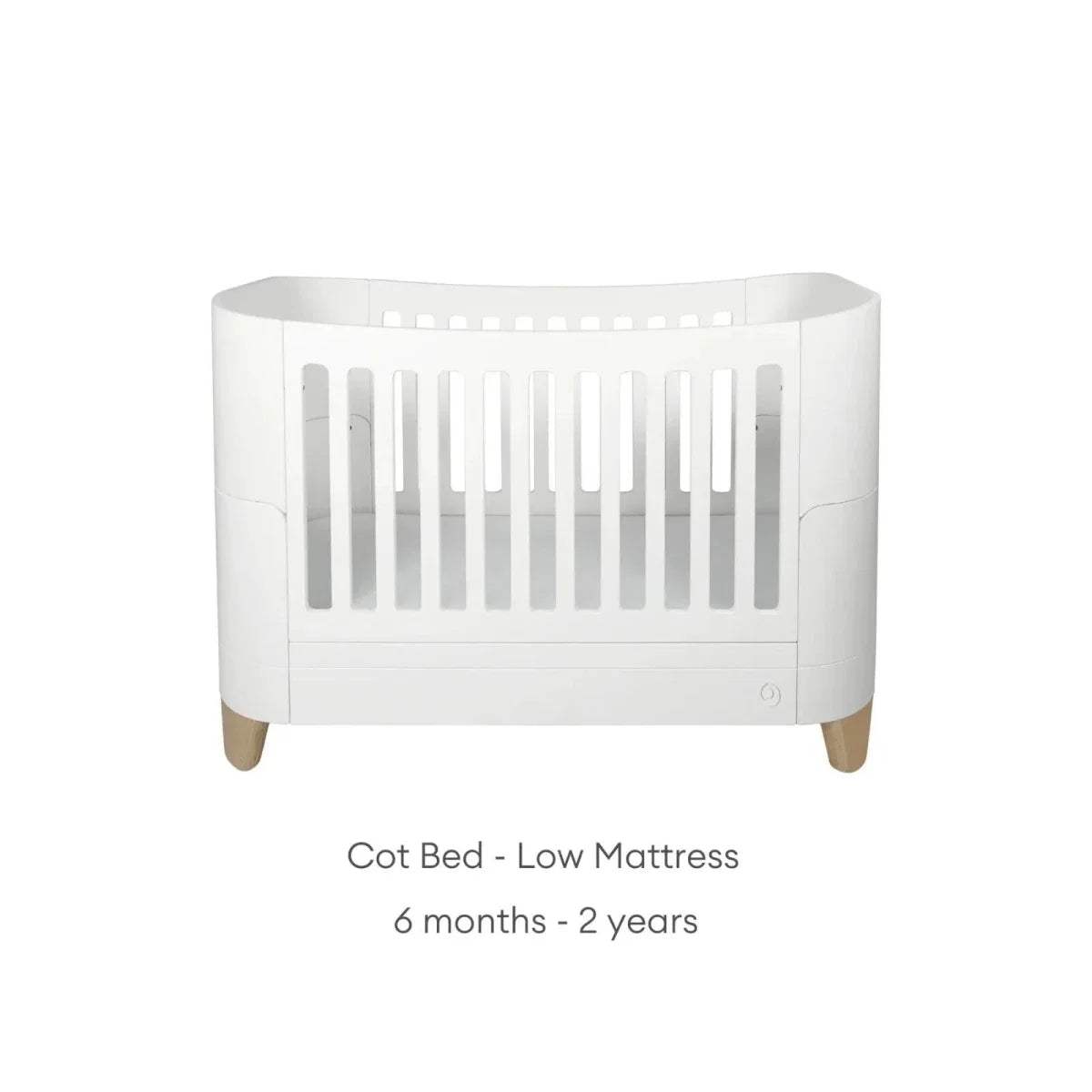 White cot bed with low slat guard and natural wooden legs