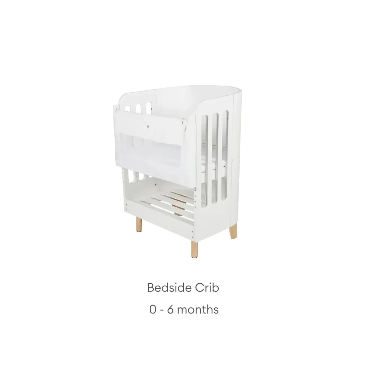 White bedside crib with slatted side panels, curved frame, and natural wood feet