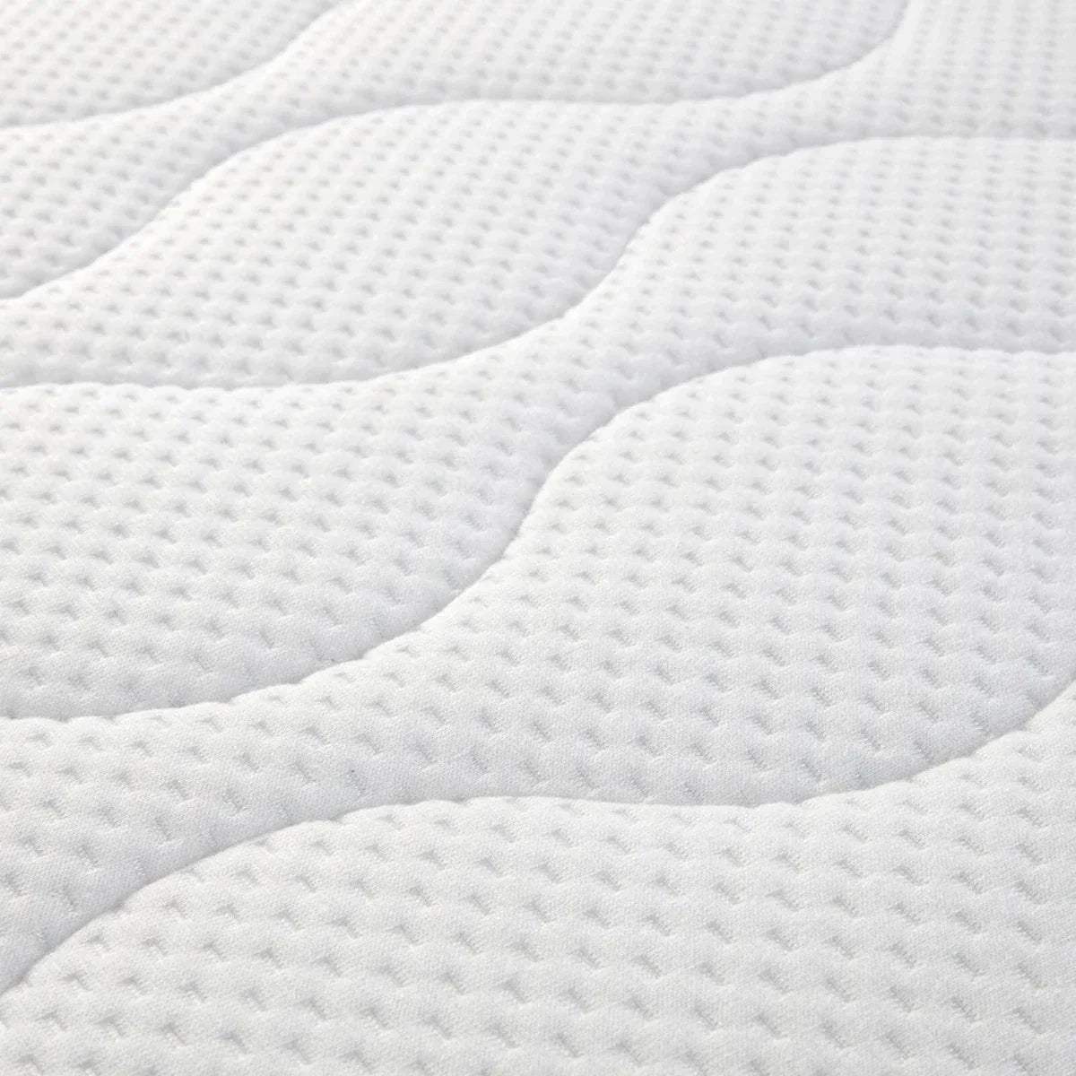White quilted cot bed mattress surface with raised wave channels