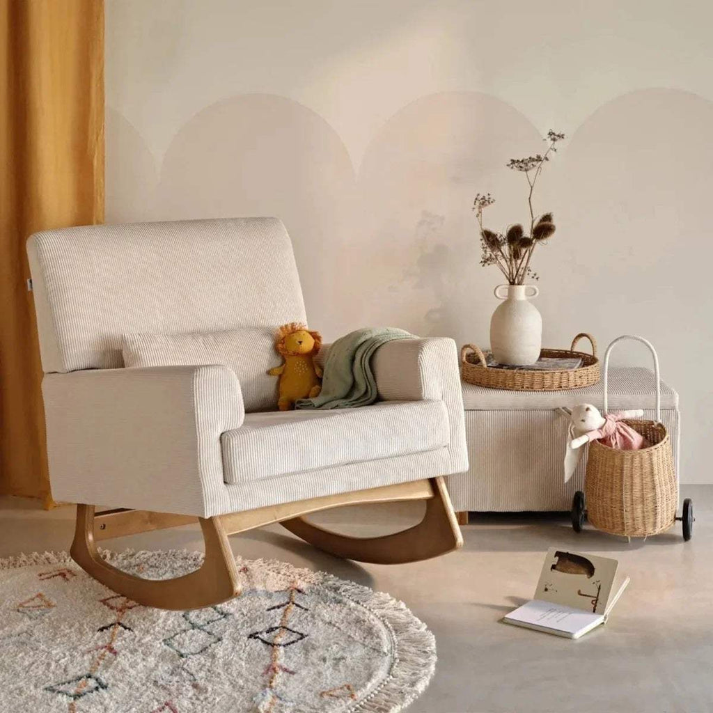 Ecru rocking nursing chair in a nursery setting with cushioned arms and curved base