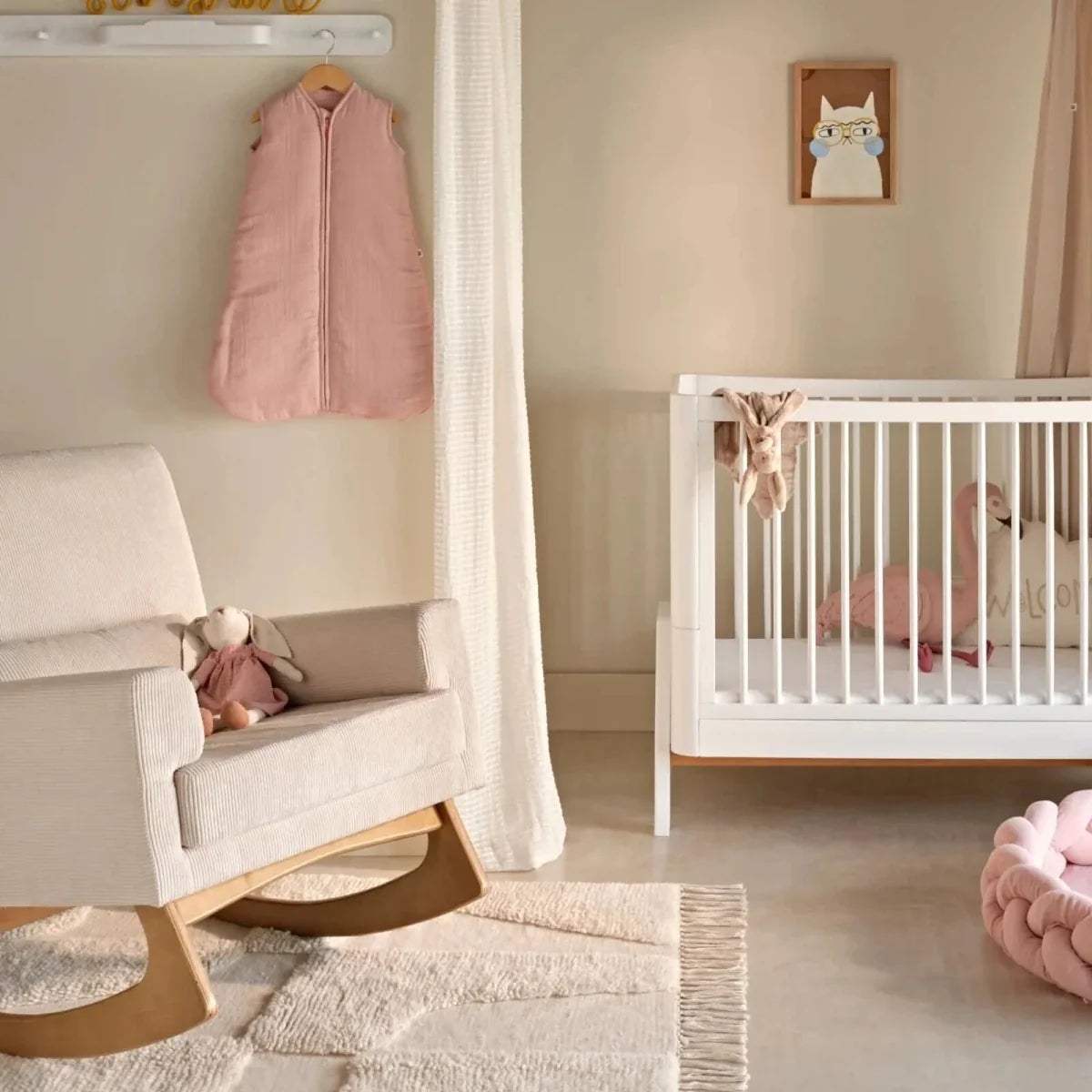 Light ecru rocking nursing chair with padded arms and rounded seat cushion
